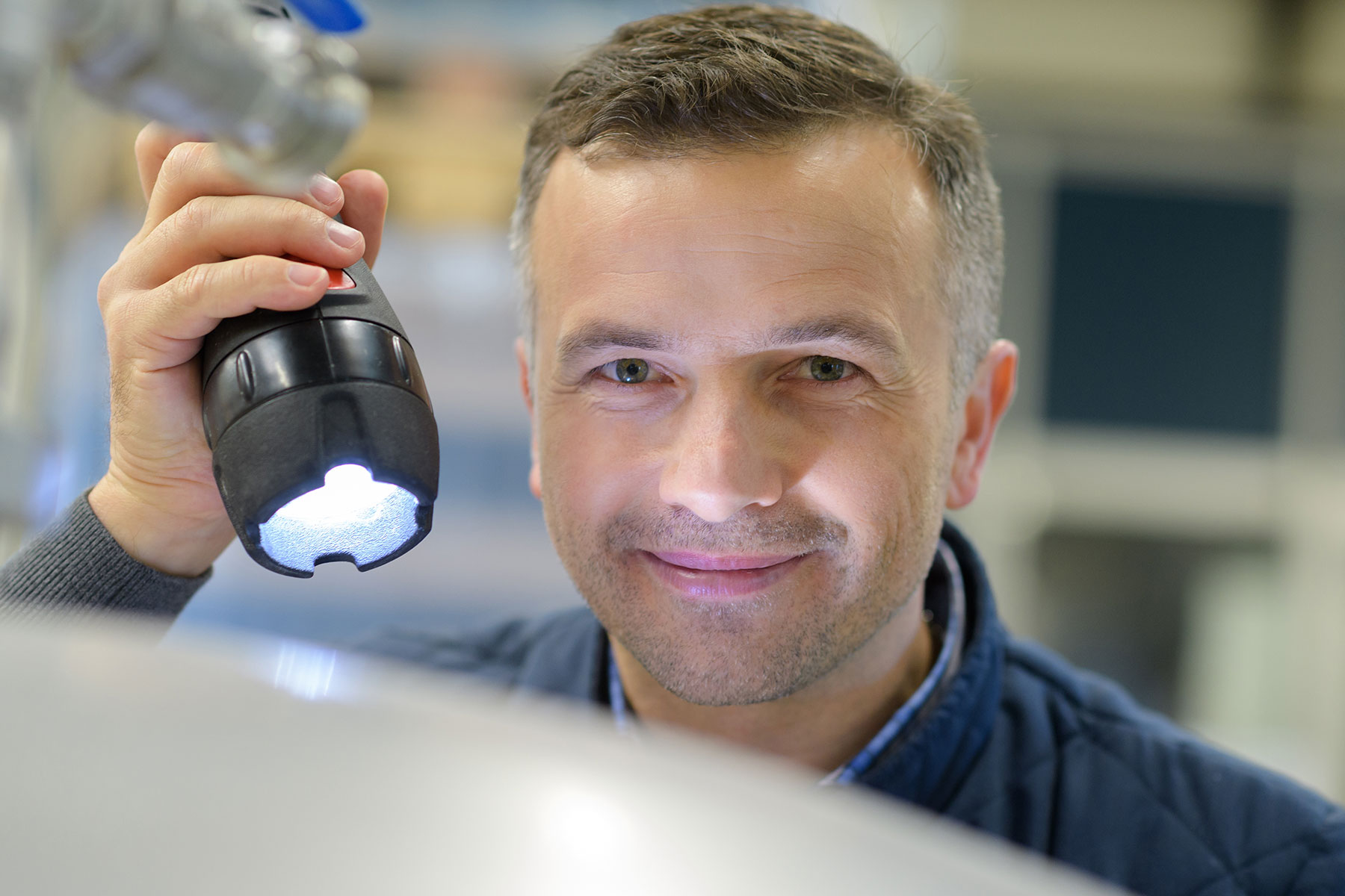 Power Outage Preparation Image of a man holding a flash light with a smile on his face
